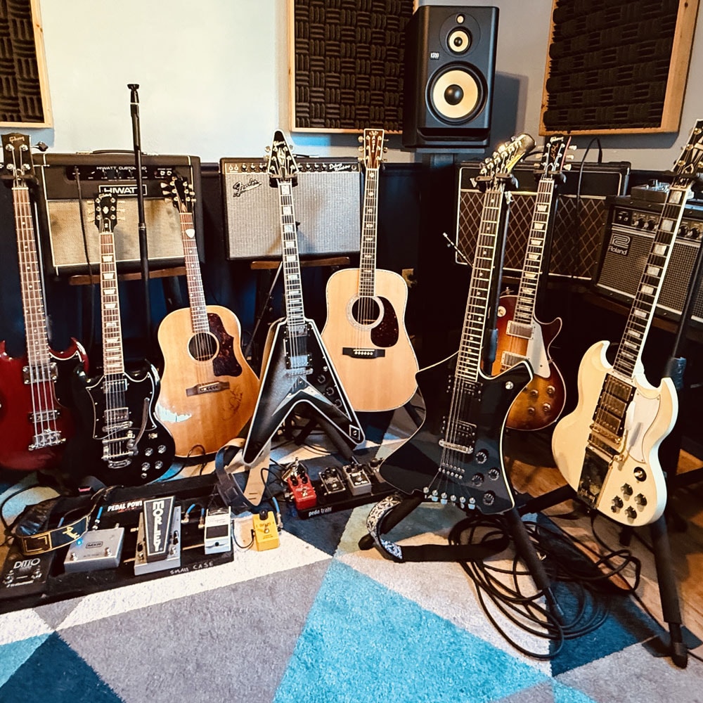 Frank Hannon's guitar collection including a blue Gretsch and white SG with Marshall stacks