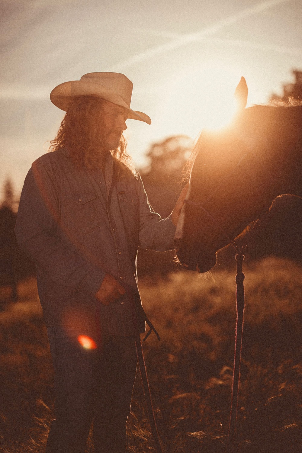 Frank Hannon with a horse at golden-hour sunset